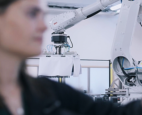 En person med en robot i bakgrunden