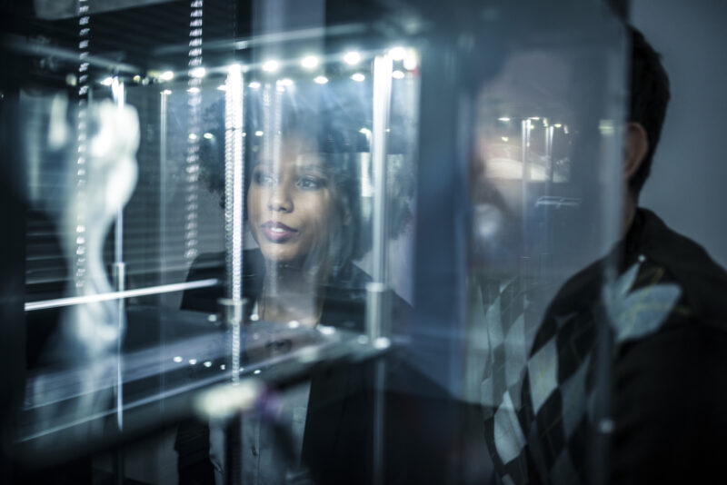 Two people looking at a 3D printer